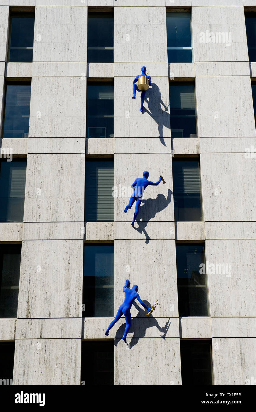 Blue Men by Ofra Zimbalista climbing Maya House on Borough High Street in London. Stock Photo