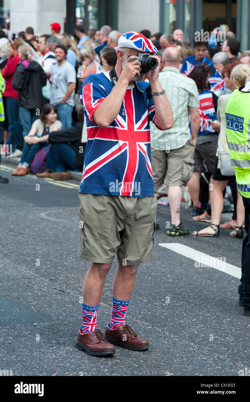 A spectator in Union Jack clothes takes photos at the London Olympics ...
