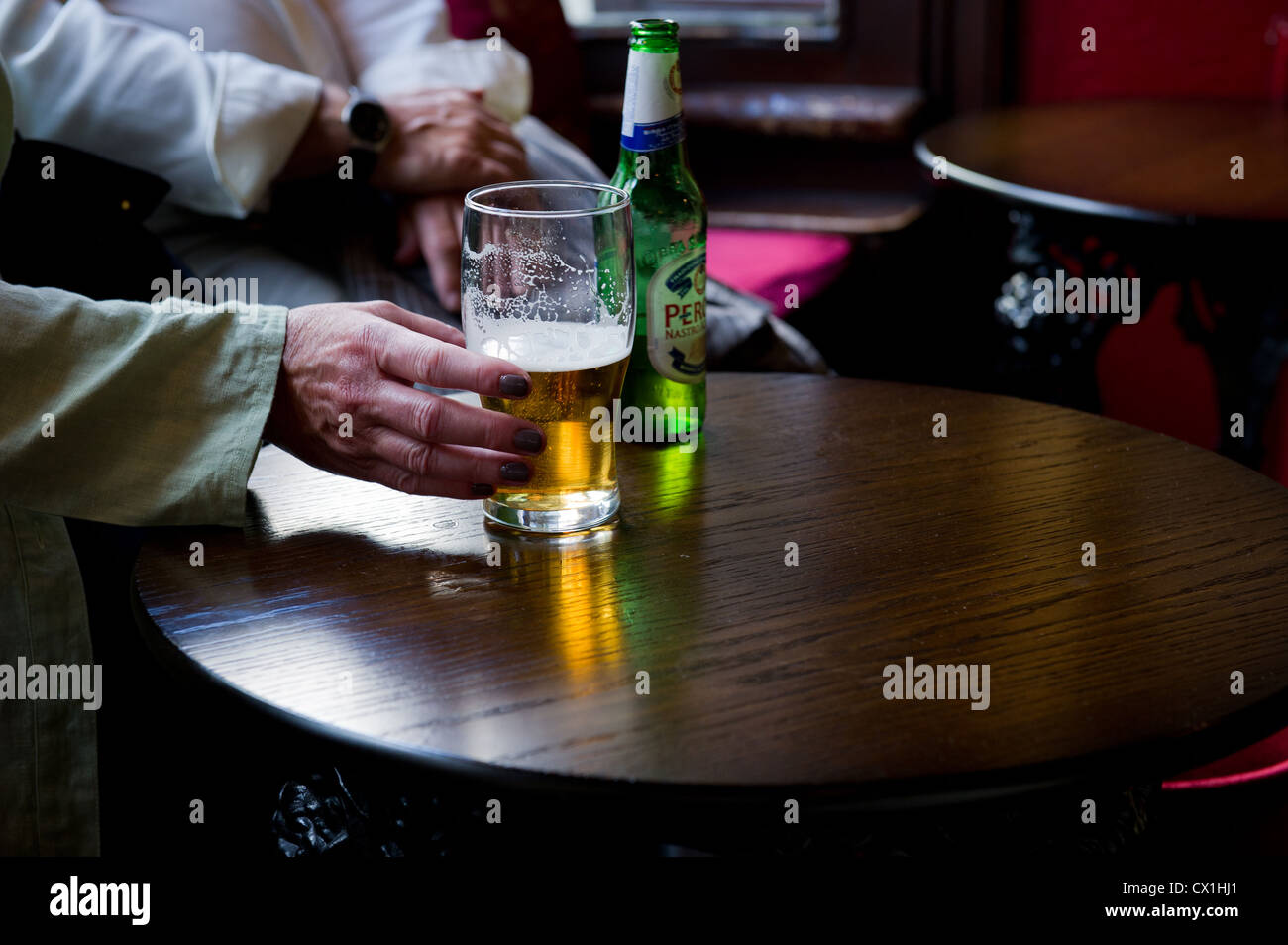 A hand rraching for a pint glass Stock Photo