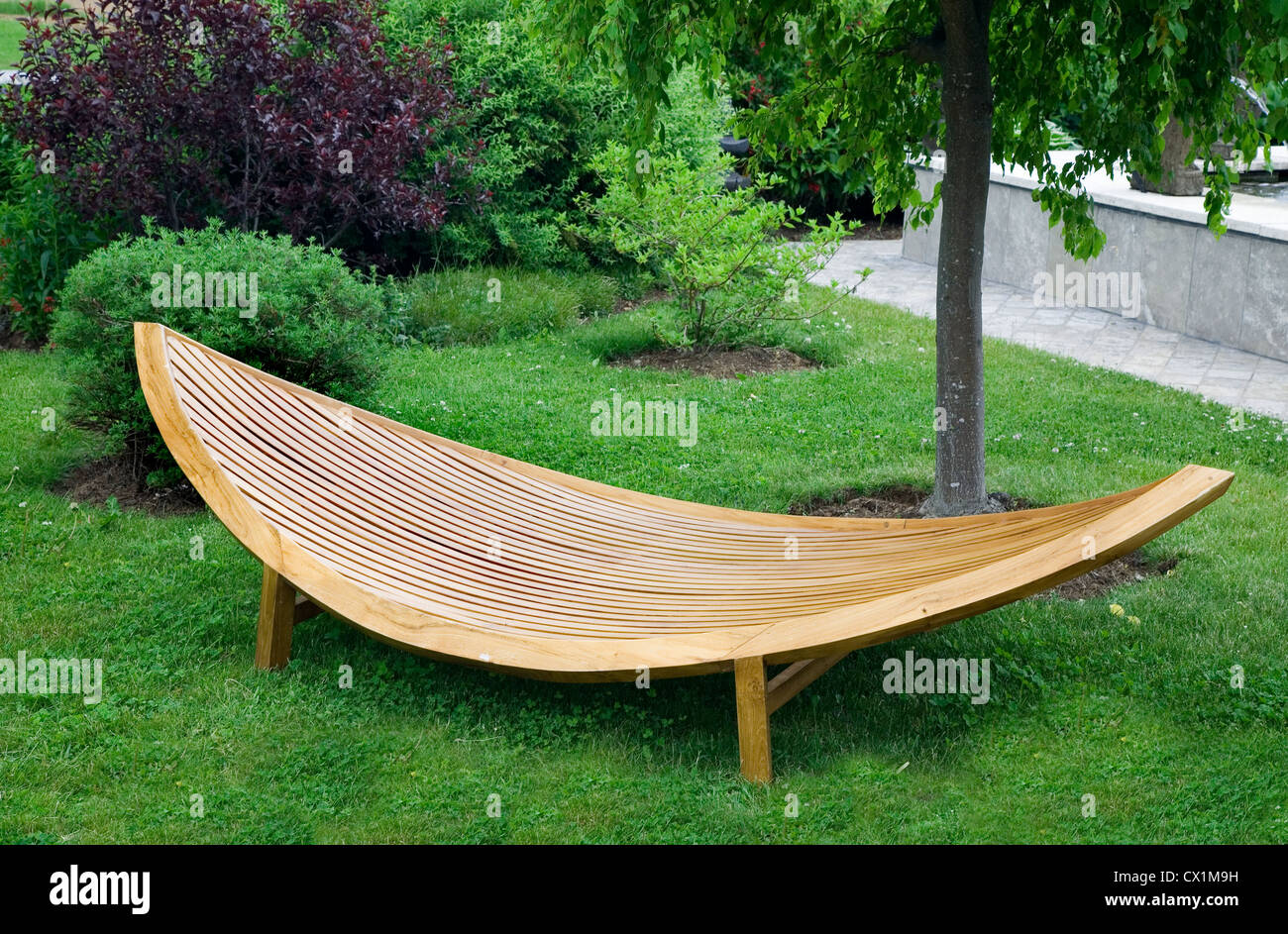Sleek modern garden furniture made of wood and varnished. Stock Photo