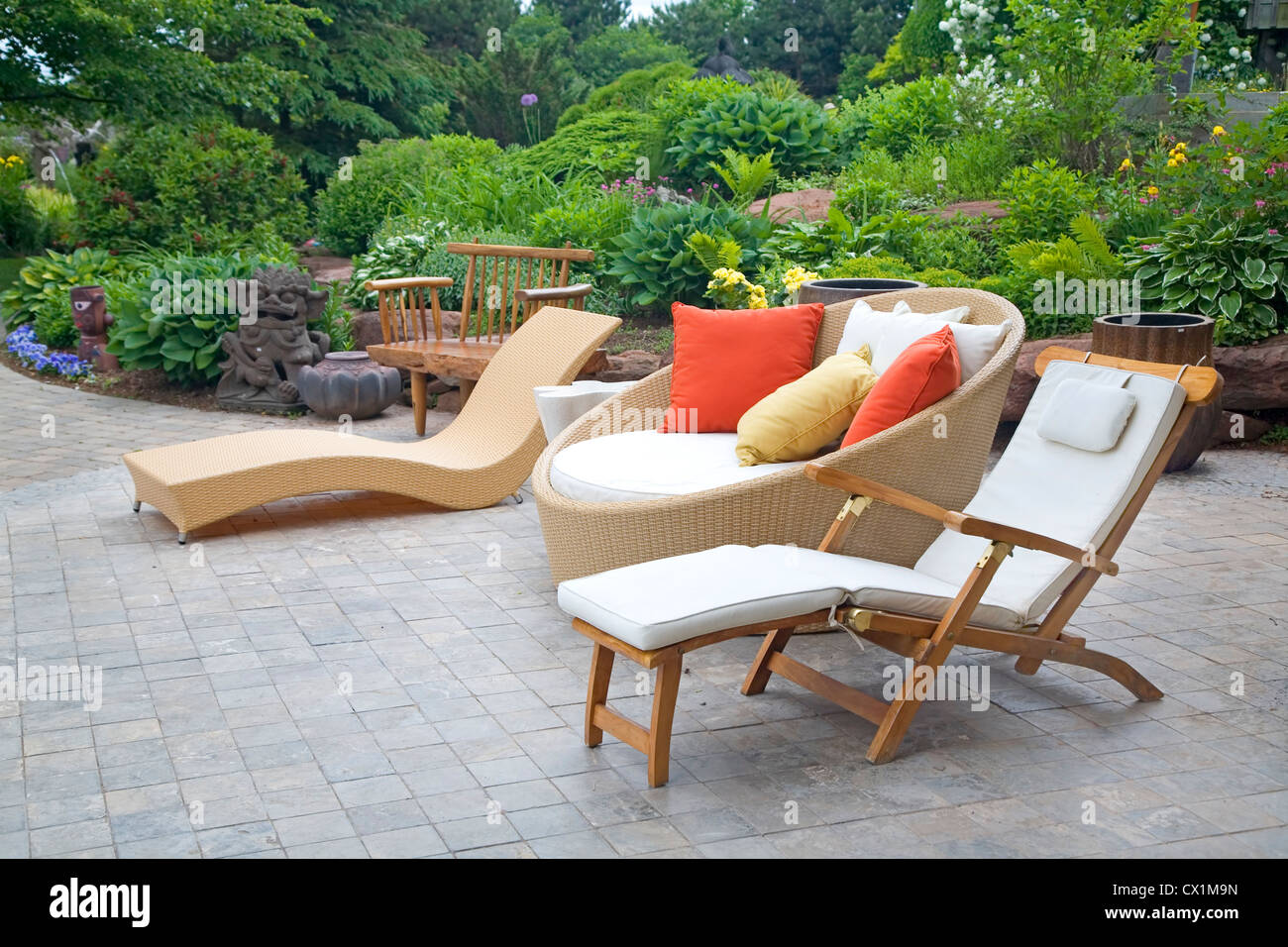 An array of modern wicker garden furniture on a patio in the home garden. Stock Photo