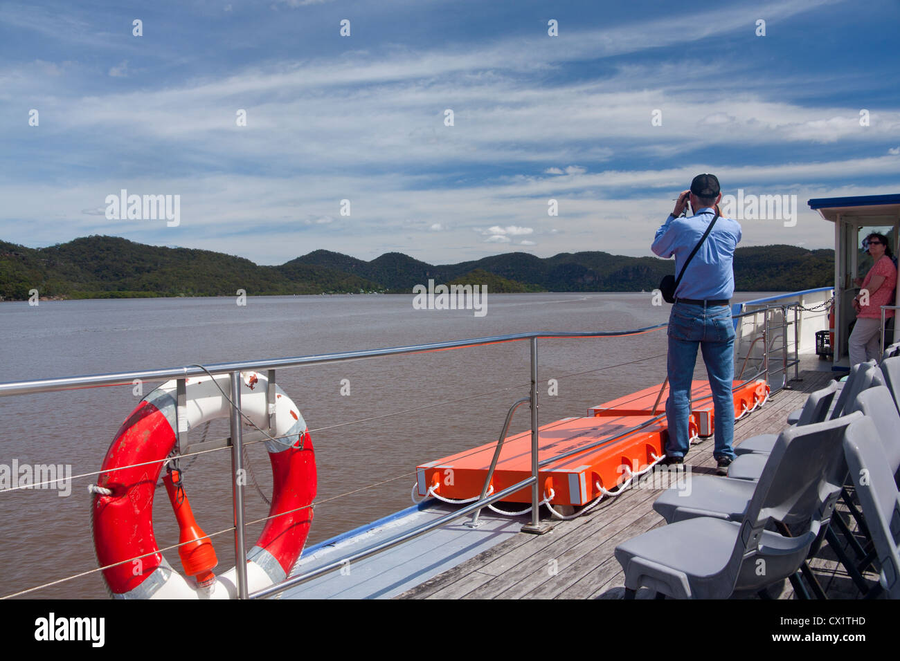 Boat trip on the Hawkesbury Riverboat Postman, with man looking through binoculars New South Wales (NSW) Australia Stock Photo