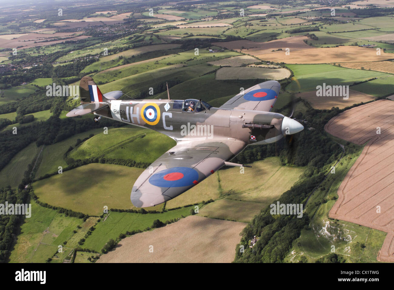 An aerial view of a Spitfire flying over Kent countryside Stock Photo