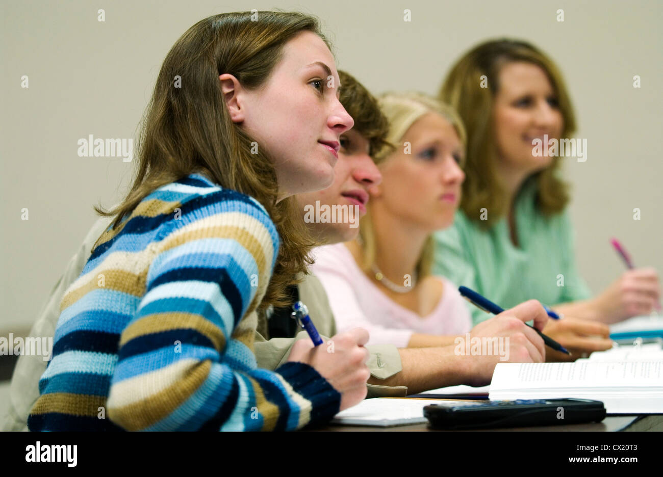 Female students listen to a college lecture in a campus classroom. Stock Photo