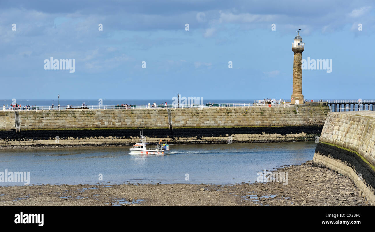 small fishing boat entering whitby harbour england Stock Photo - Alamy