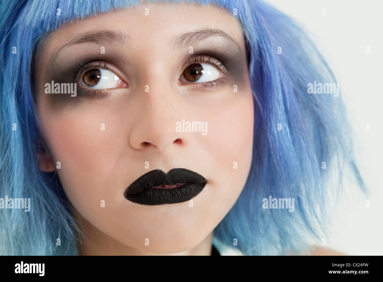 Close-up of young female punk with black lipstick, eye make-up and blue hair Stock Photo