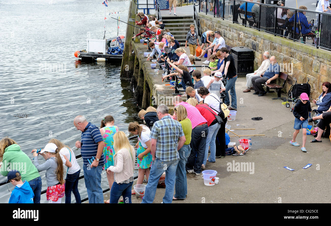 holidaymakers crabbing in whitby harbour north yorkshire england uk