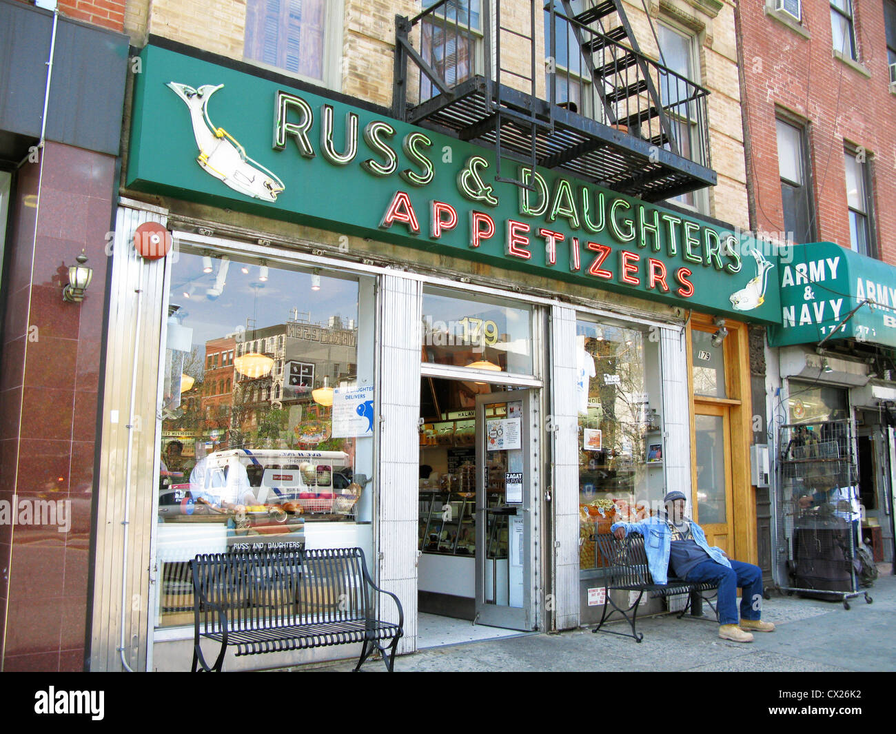 Front of Russ & Daughters food shop, restaurant, delicatessen, smoked fish, bagels, man lounging on bench, New York Stock Photo