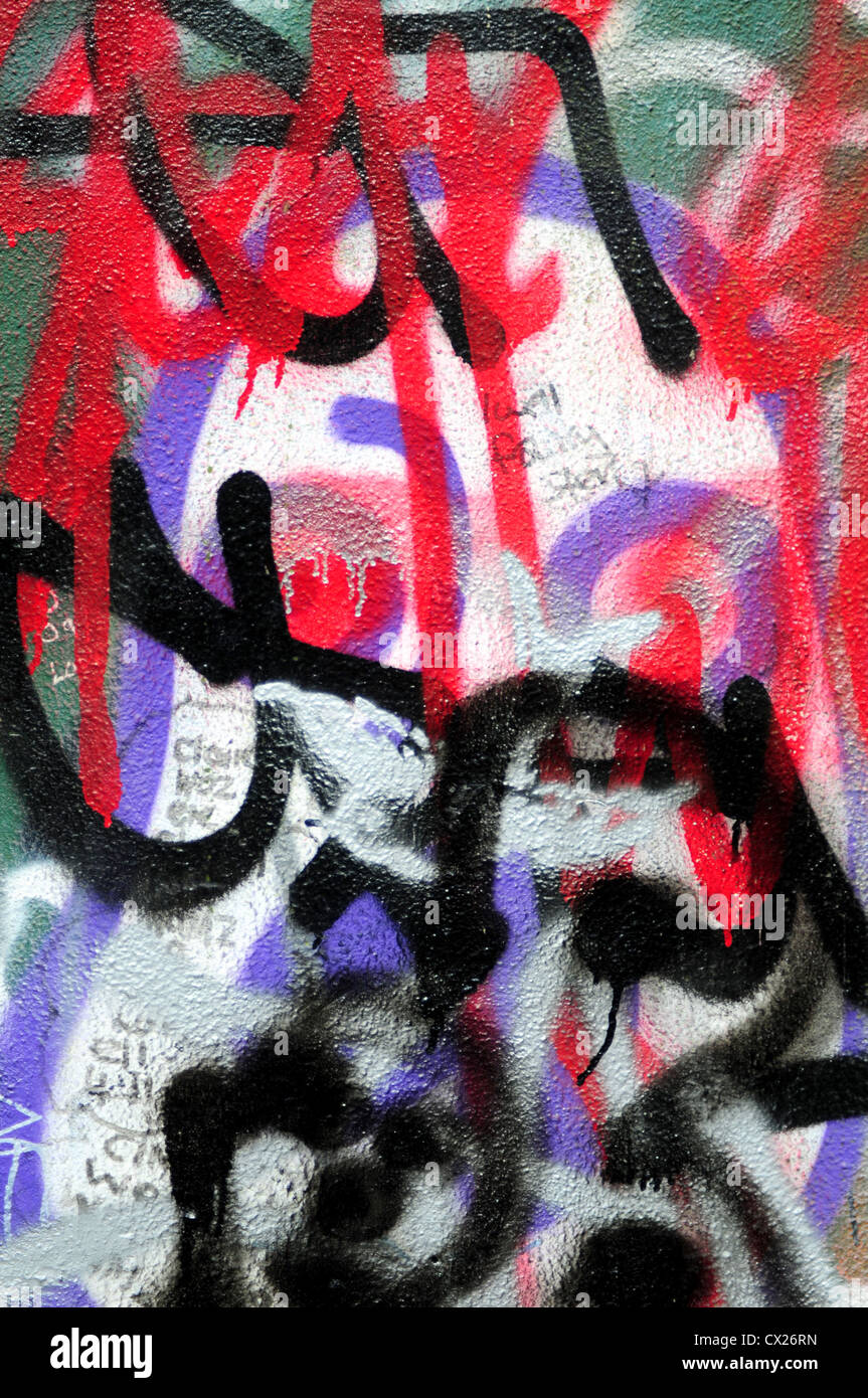 Sprayed graffiti on wall using red, black and purple colours Stock Photo