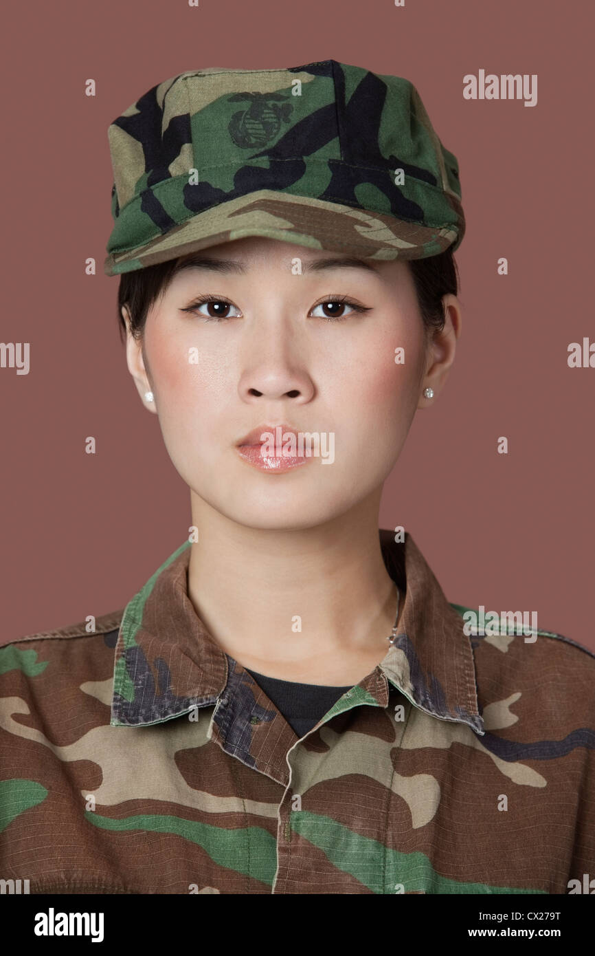 Portrait of beautiful young US Marine Corps soldier in camouflage clothing over brown background Stock Photo
