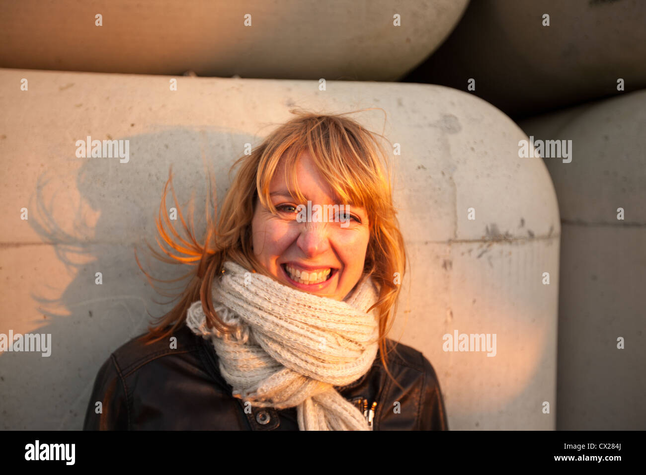 Blonde girl flirting at sunset near industrial area Stock Photo