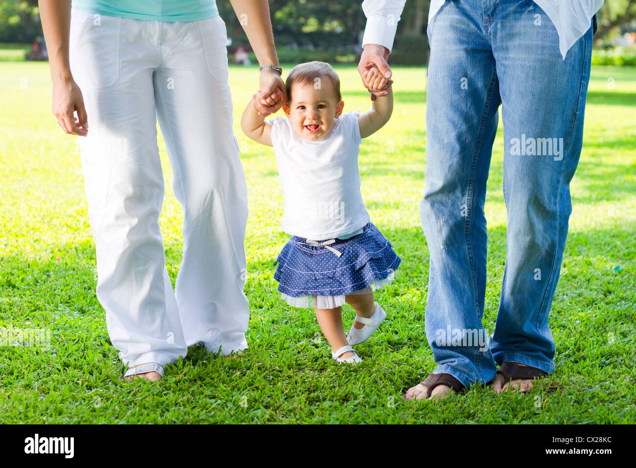 cute baby girl walking in park with parents Stock Photo - Alamy