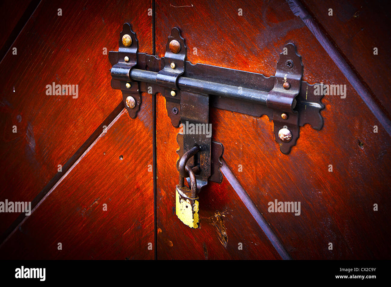 Rusty old lock, latch on wooden closed door with a modern padlock Stock Photo Alamy