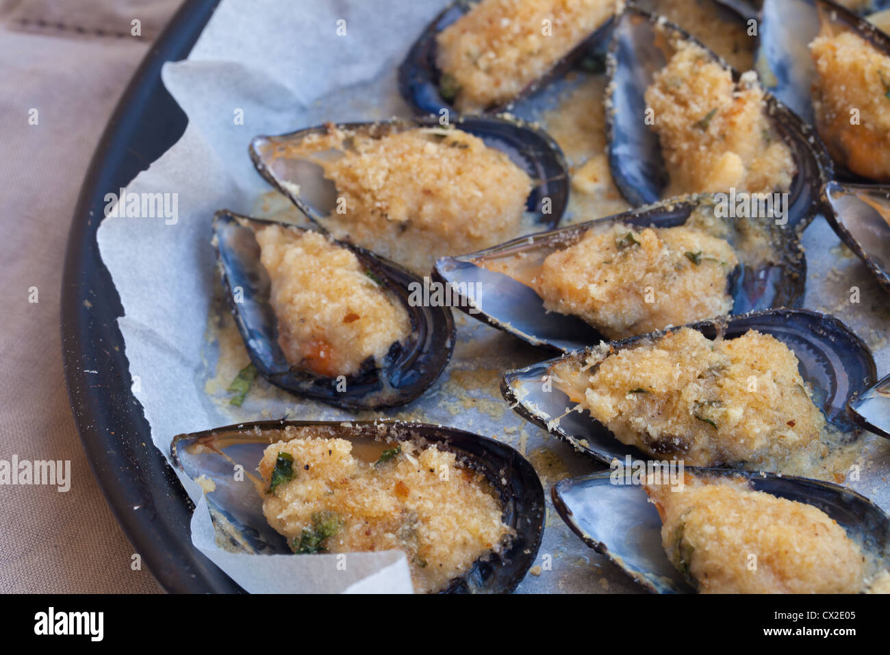 Baking tin full of tasty mussels au gratin Stock Photo Alamy