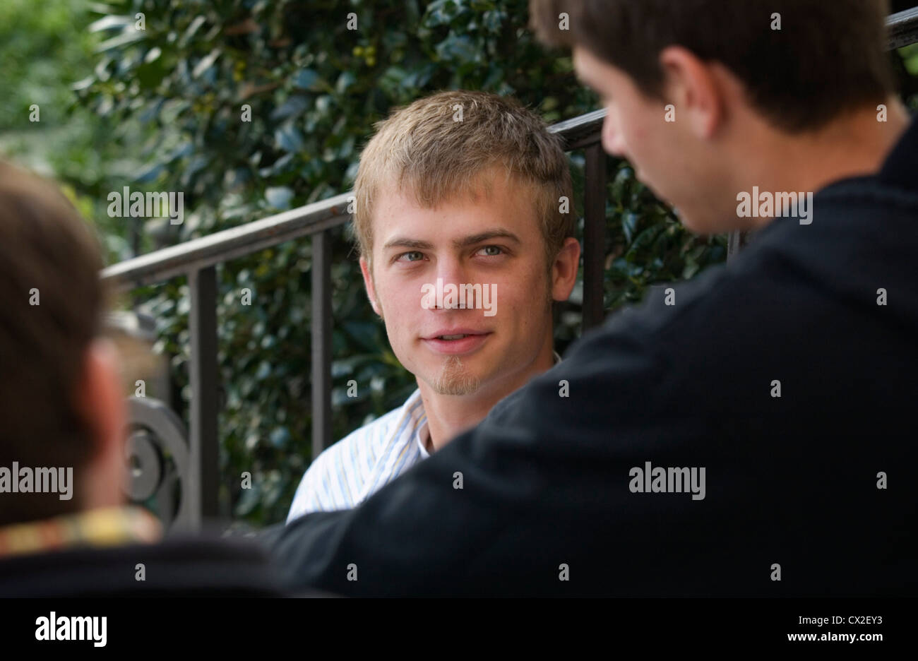 A male college student converses with his friends between classes Stock Photo