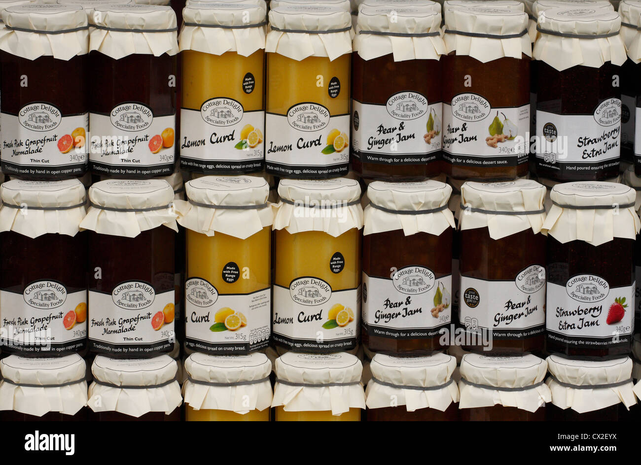 Jars of preserves, including lemon curd and strawberry jam for sale at a farmers' market in Derbyshire, UK Stock Photo