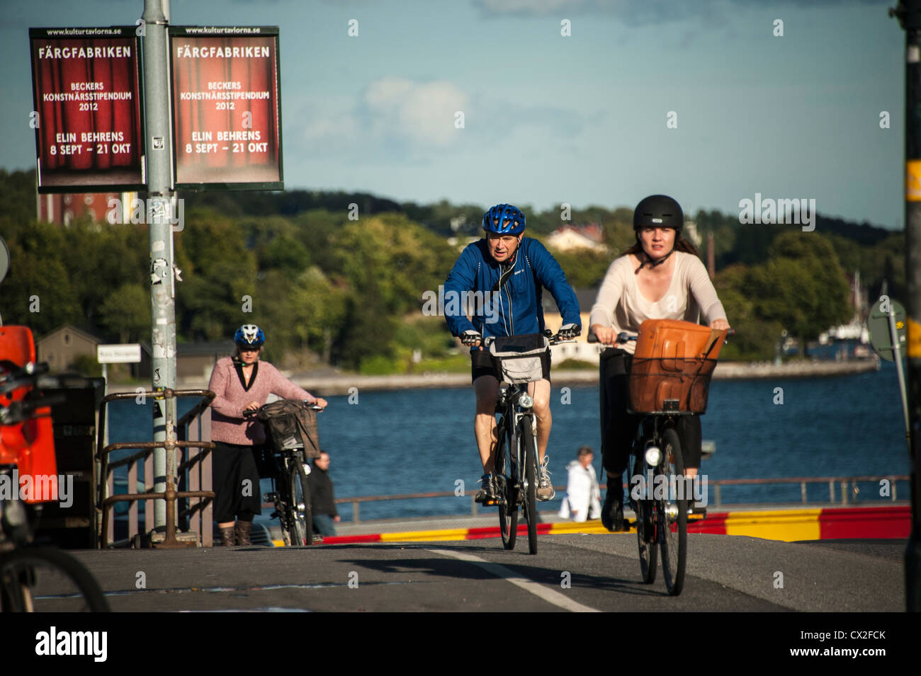 Communters on bicycles passing Gamla Stan The Old Town and Slussen In Stockholm Stock Photo
