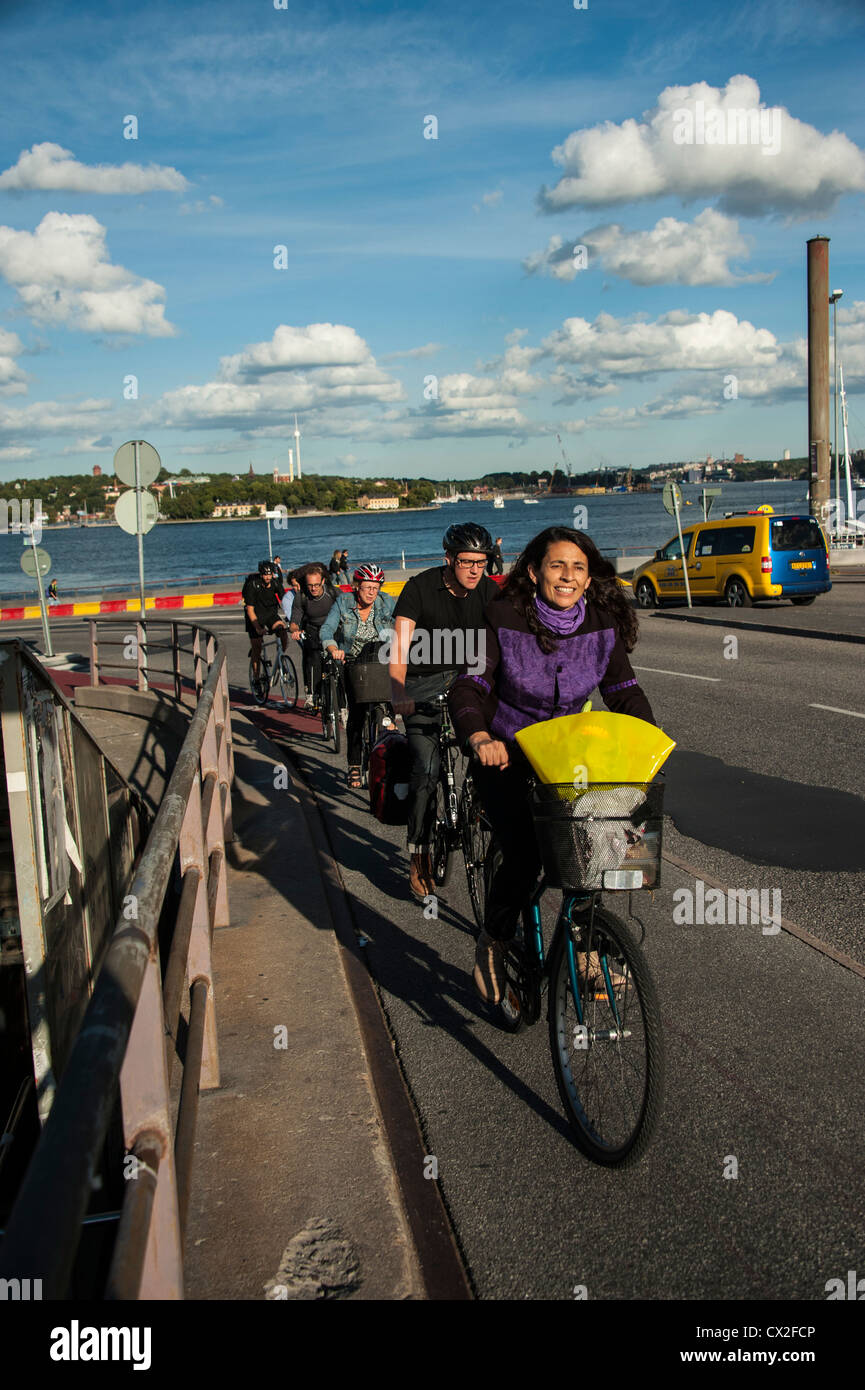 Communters on bicycles passing Gamla Stan The Old Town and Slussen In Stockholm Stock Photo