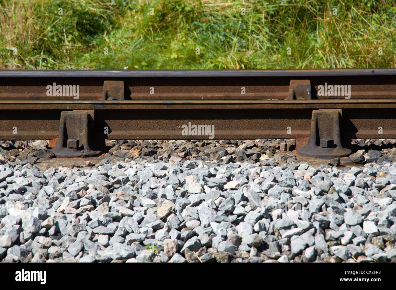 Railway track  - chaired bullhead rail, concrete sleepers. Rail held in cast iron chairs by wood/metal key. Stock Photo