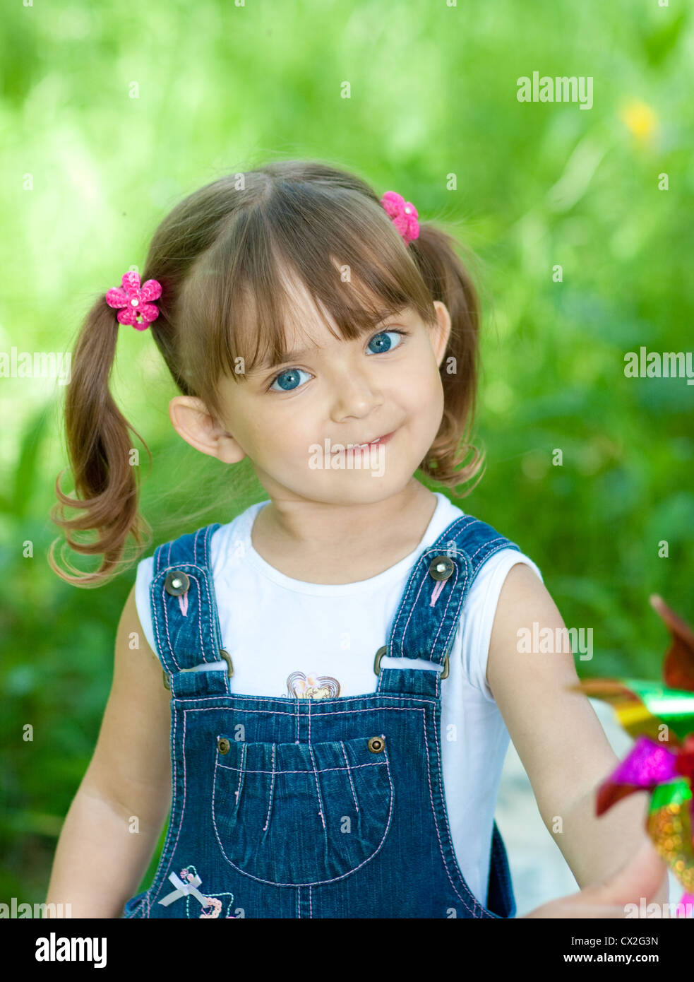 Little girl in jeans with blue eyes outdoor Stock Photo