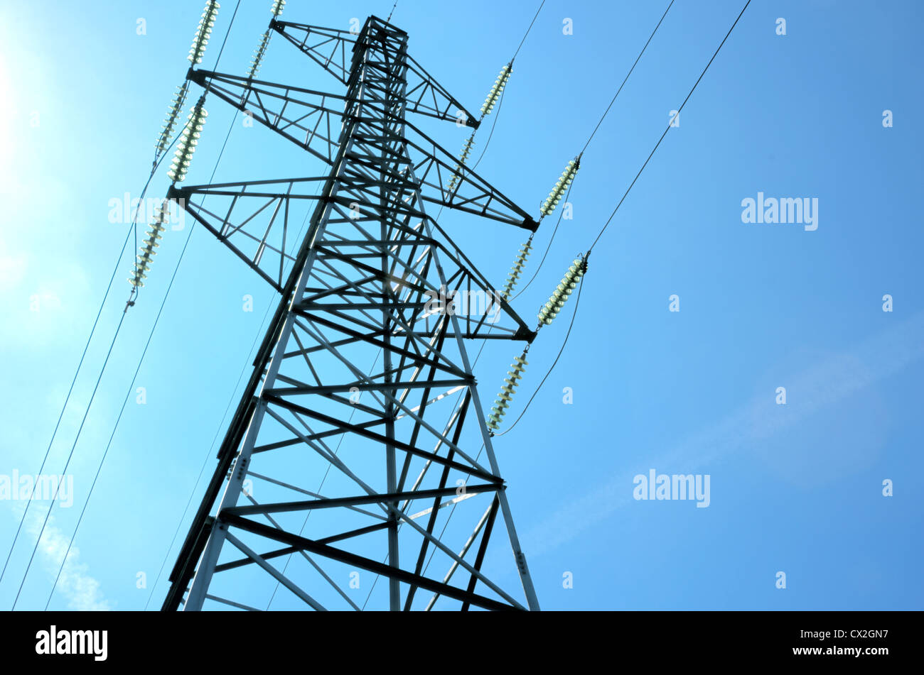 An electricity power tower against a blue sky Stock Photo