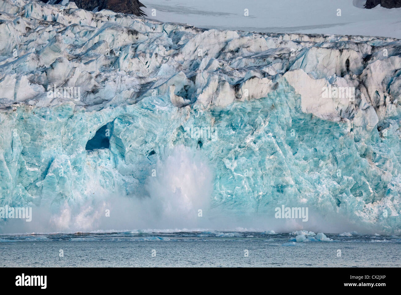 Large chunk of ice breaking off glacier and tumbling with big splash in the Magdalenefjord on Svalbard, Spitsbergen, Norway Stock Photo