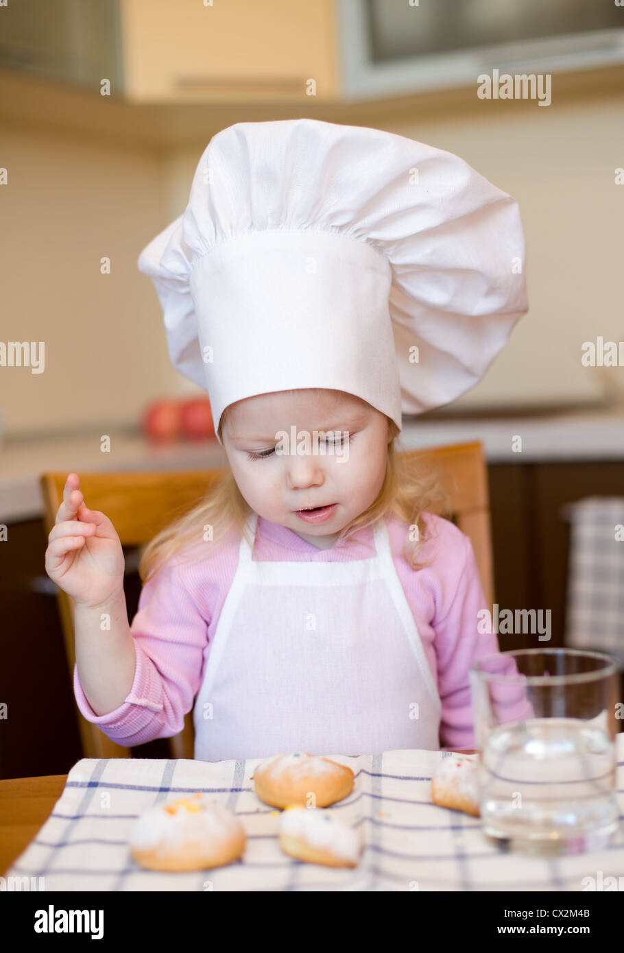 Little girl ready to eat cakes on kitchen Stock Photo