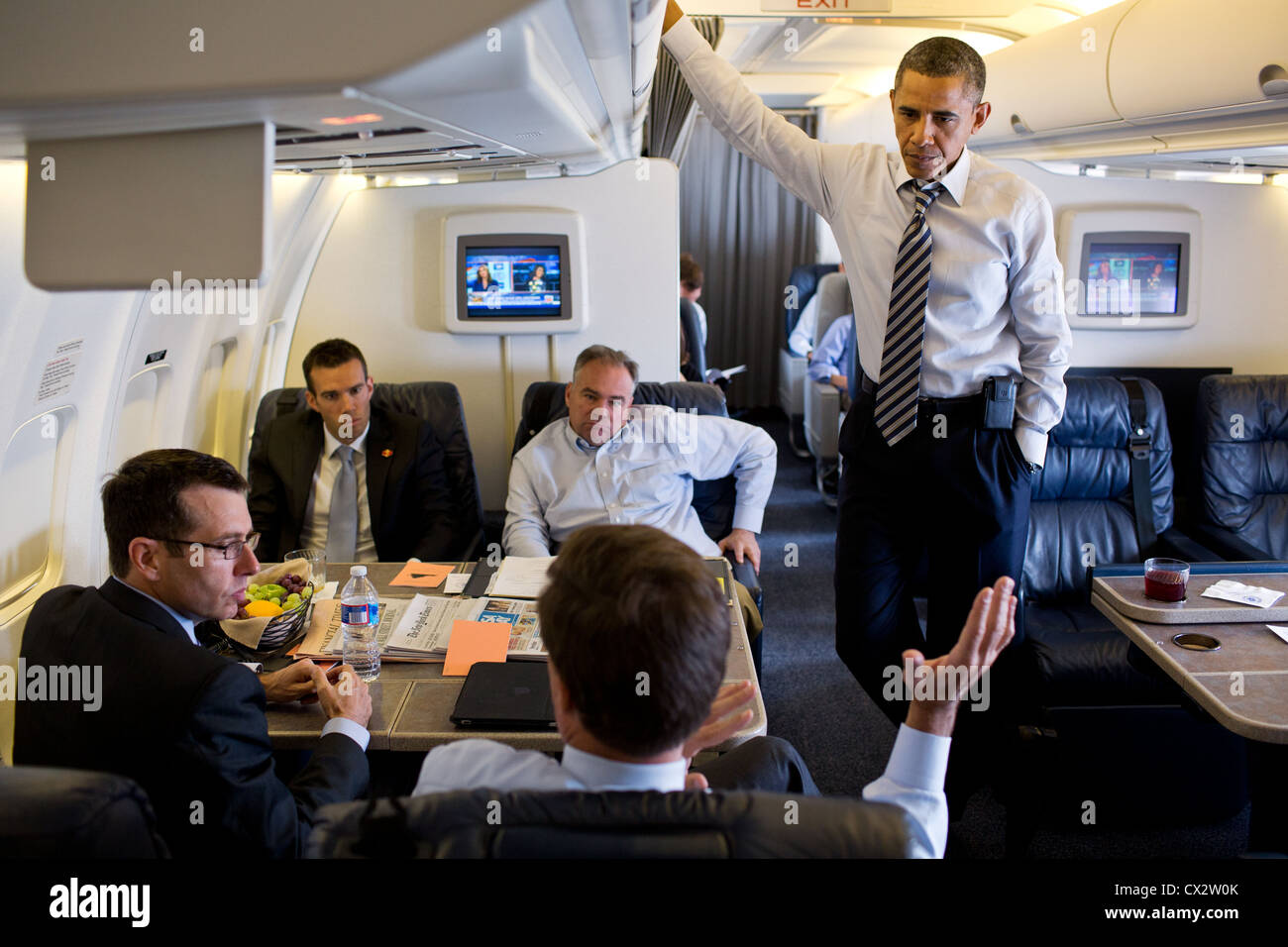 Obama listens to Sen. Mark Warner, D-Va., aboard Air Force One during a flight to Norfolk, Va., July 13, 2012. Stock Photo