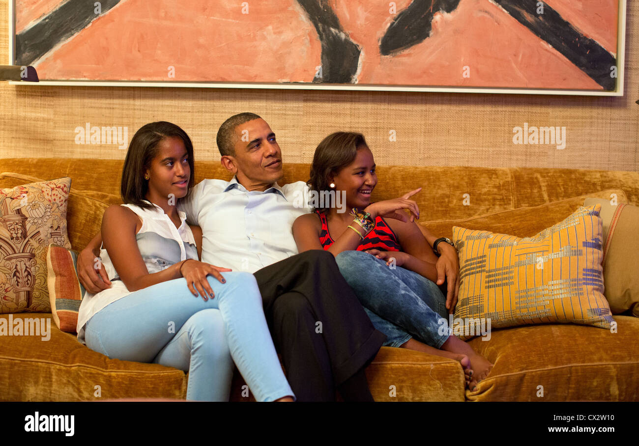 President Barack Obama and his daughters, Malia, left, and Sasha, watch on television as Michelle speaks at DNC Stock Photo
