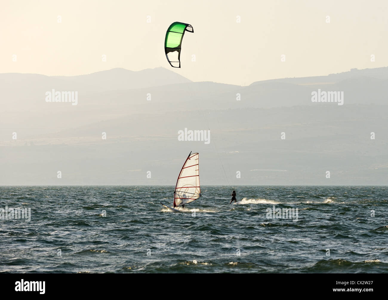Sky-surfing and surfing in the rays of the setting sun on lake Kinneret Stock Photo
