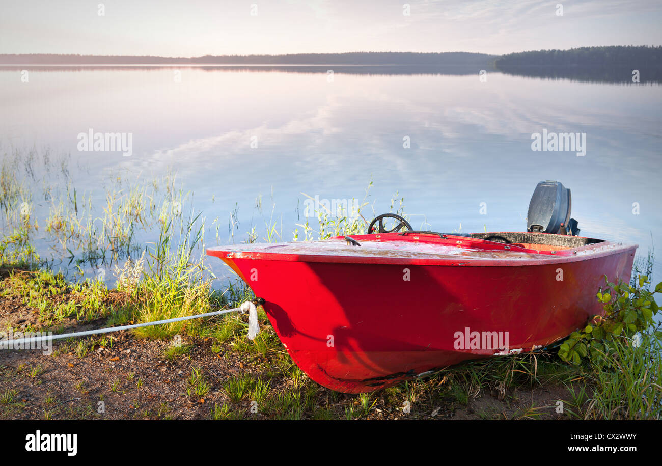 Red motorboat moored on the coast of Saimaa lake, Finland Stock Photo