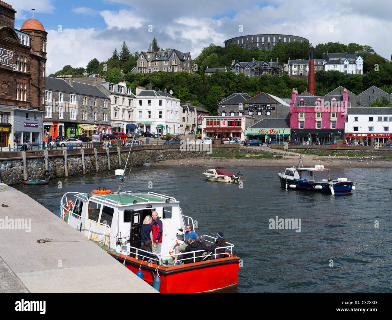 dh  OBAN ARGYLL Tourist boat trip Oban North pier seafront McCaigs Tower holidaymakers people scotland holiday uk Stock Photo