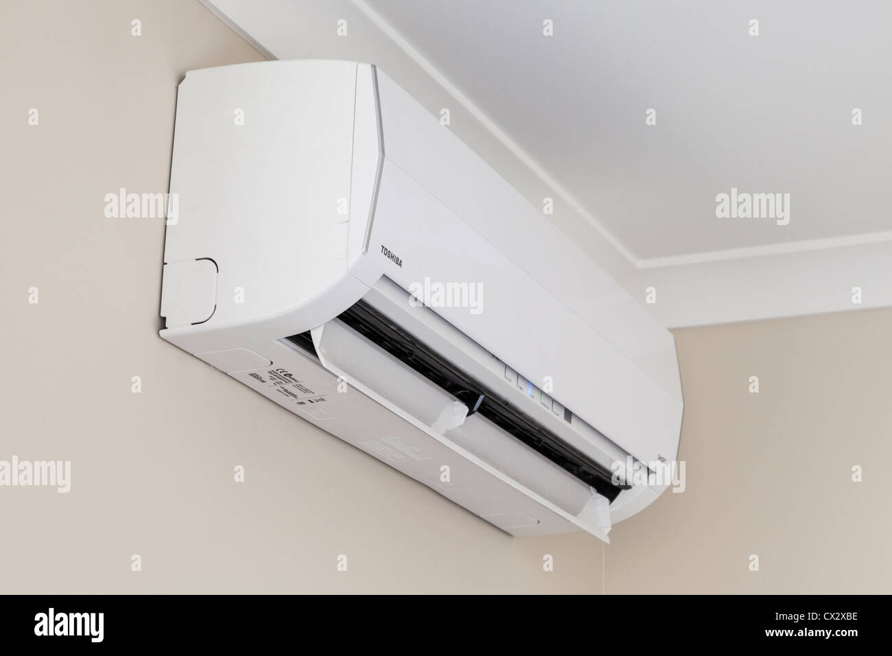 Toshiba heat pump, or reverse cycle air conditioner, installed high on a wall and running. Stock Photo