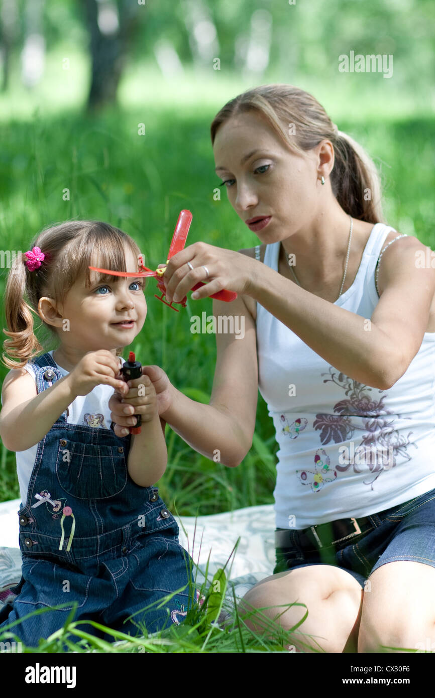 Mother and daughter in jeans with toy outdoor Stock Photo