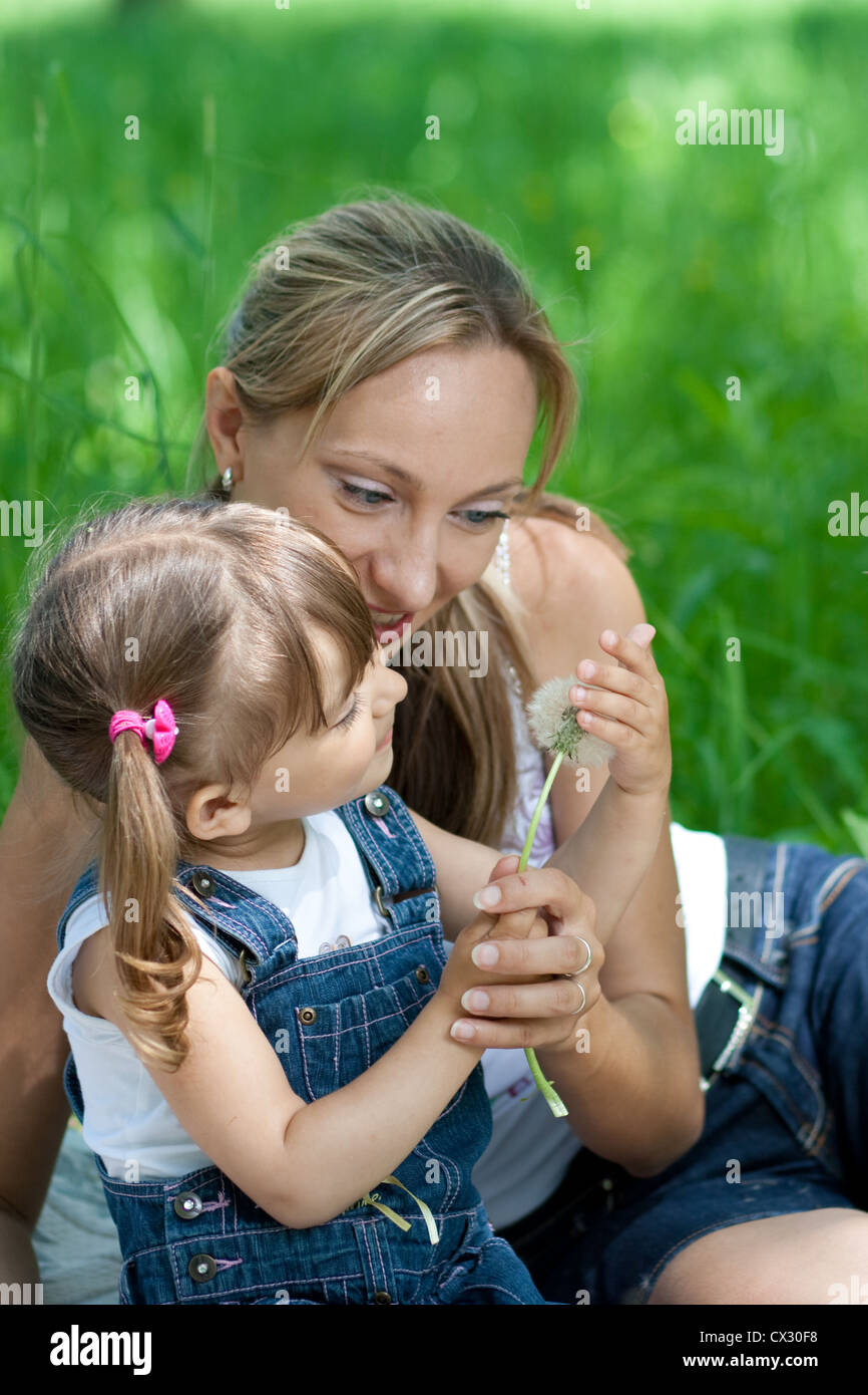 Mother and daughter in jeans with dandelion outdoor Stock Photo