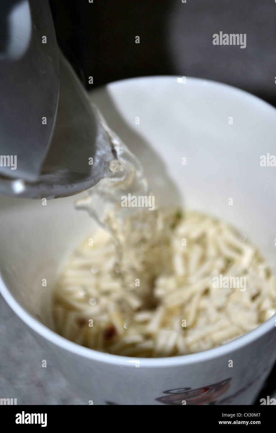 pouring boiling water onto cup-a-soup noodles Stock Photo