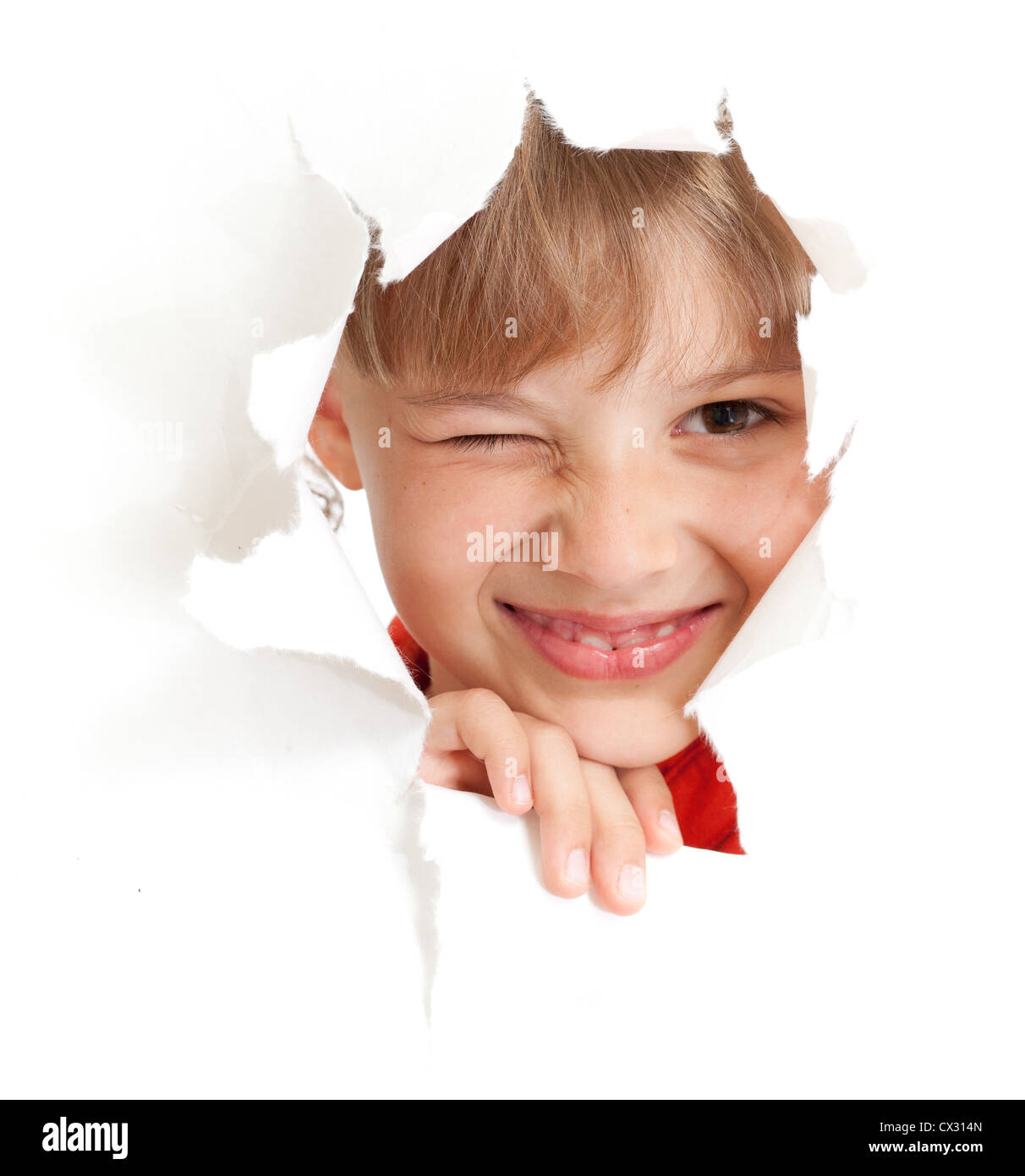 funny kid with wink eye portrait in torn paper hole isolated Stock Photo