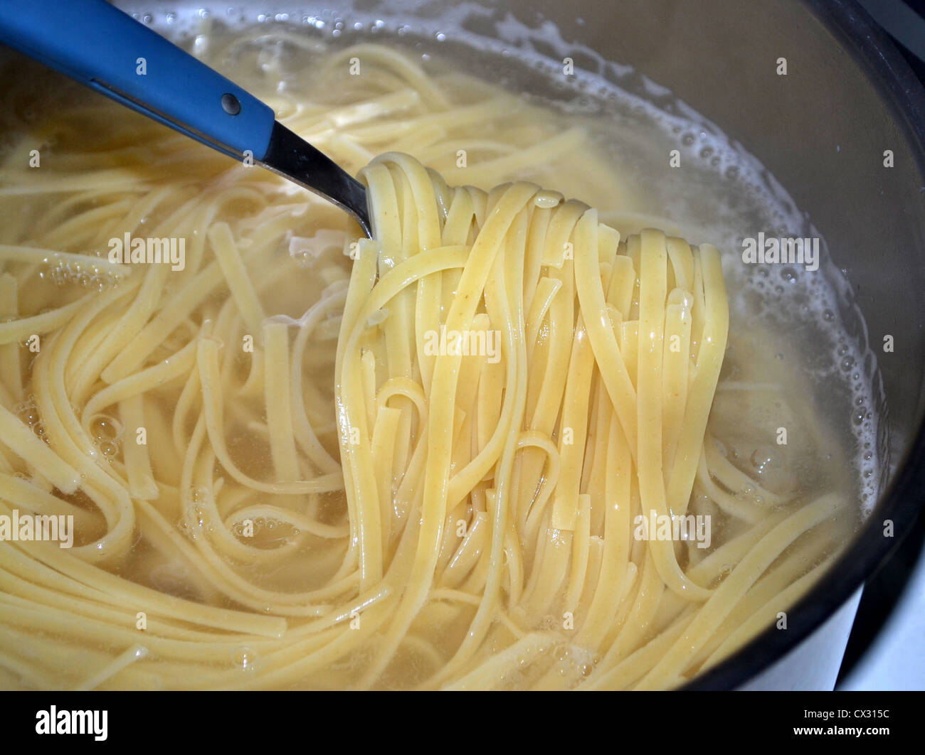 Linguine (also 'linguini') is a form of pasta — flat like fettuccine and trenette. Cooking in pot of boiling water Stock Photo