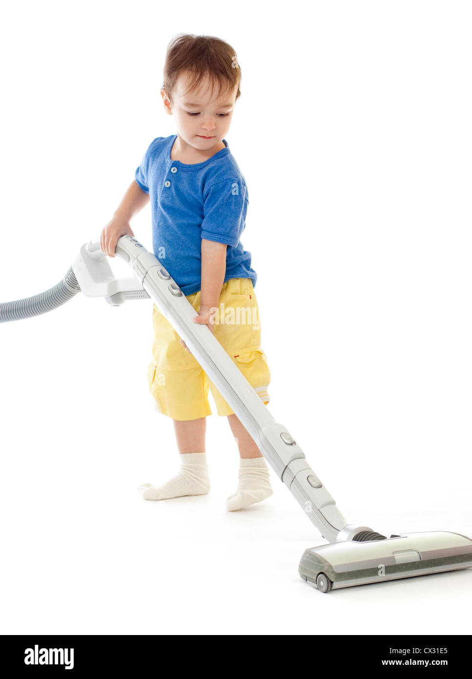 Toddler is cleaning room with vacuum cleaner isolated on white Stock Photo