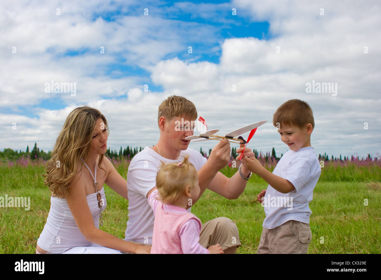 Happy family launching toy aircraft model together Stock Photo
