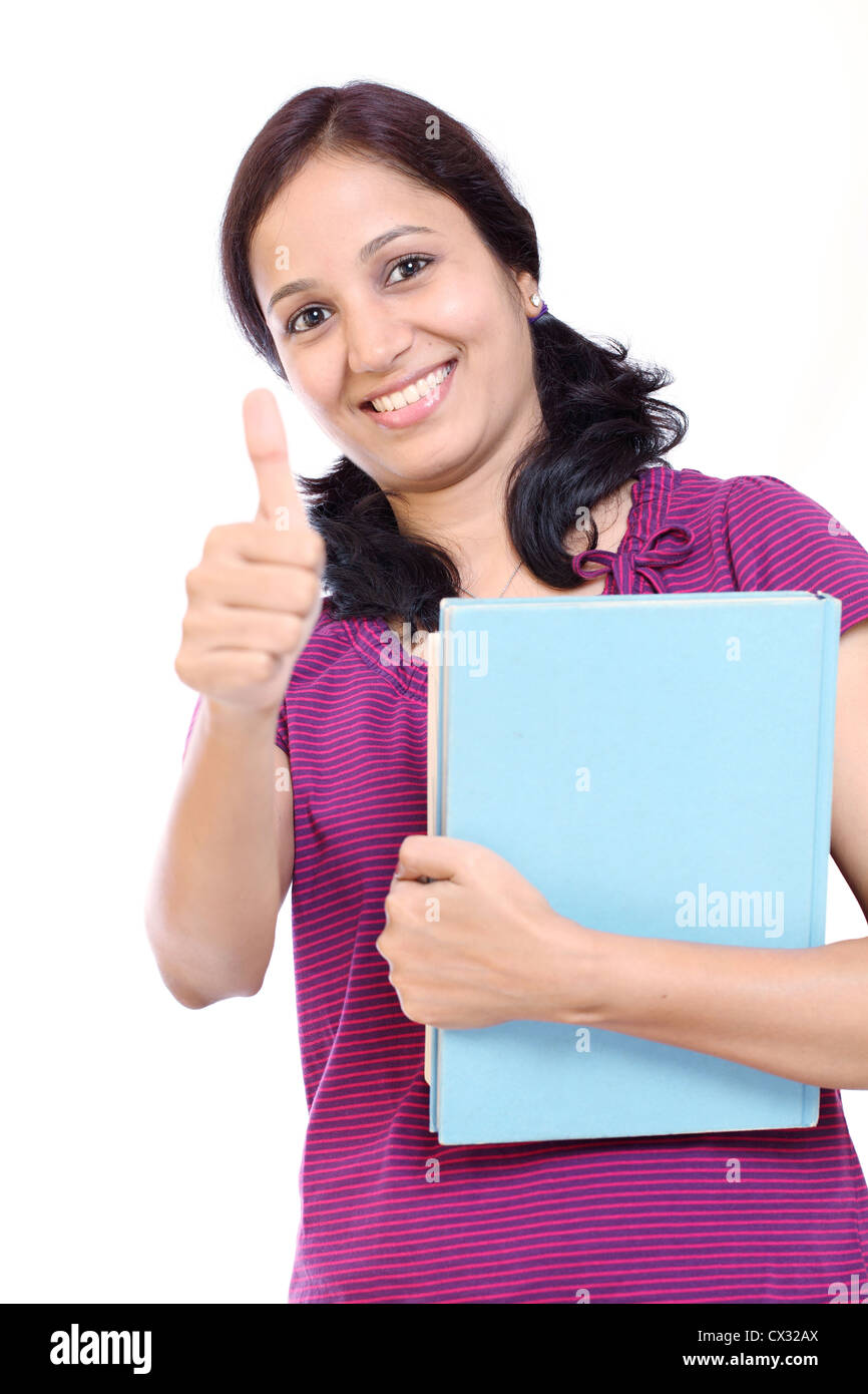 Smiling young female student showing thumbs up against white Stock ...