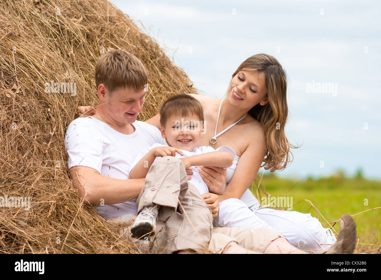 Happy family has fun in haystack together Stock Photo