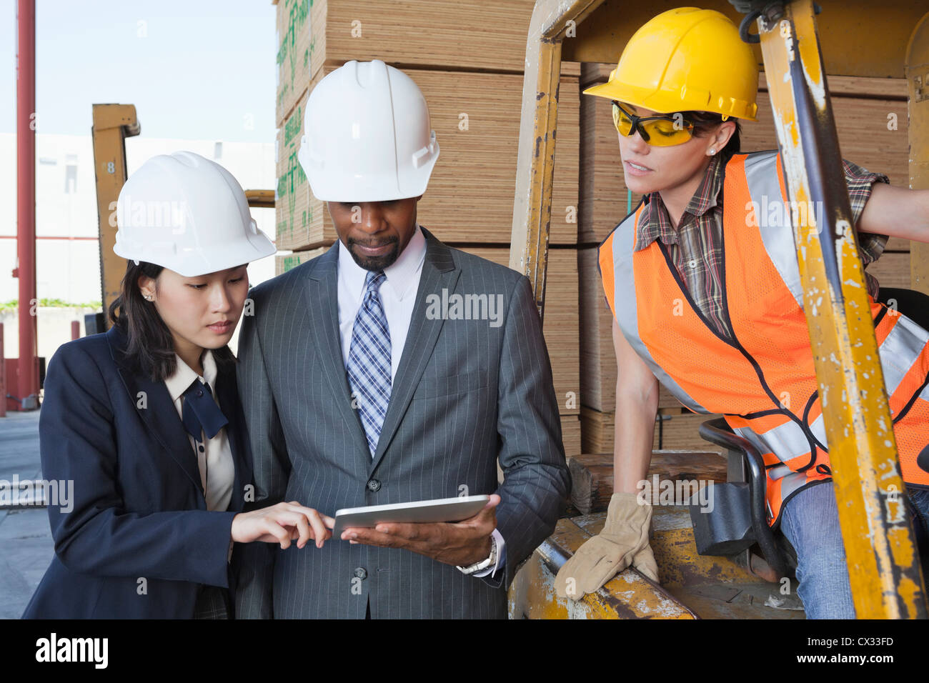 Engineers and female industrial worker looking at tablet PC Stock Photo