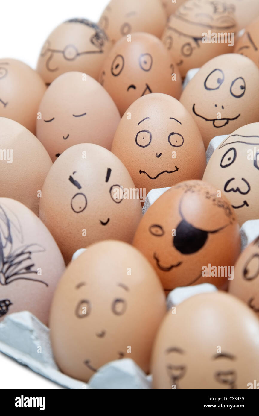 Anthropomorphic brown eggs arranged in carton against white background Stock Photo