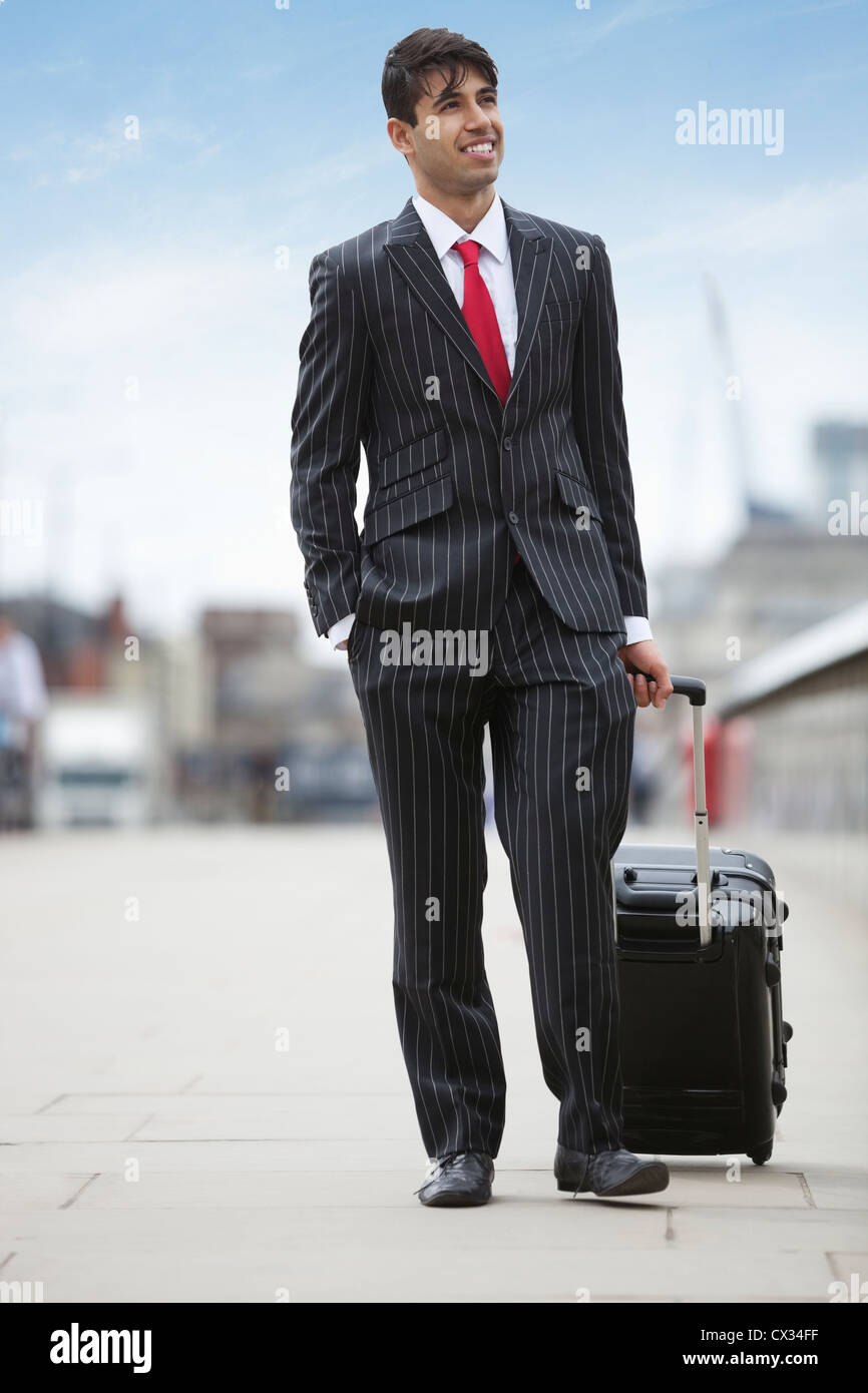Young Indian businessman pulling luggage bag on street Stock Photo Alamy
