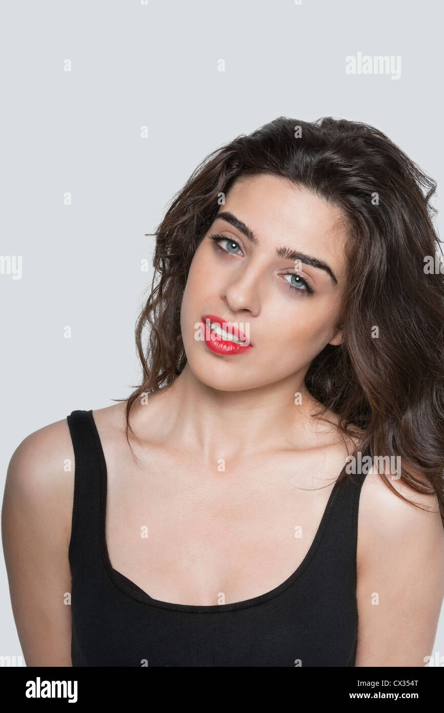 Portrait of a beautiful young woman over gray background Stock Photo ...
