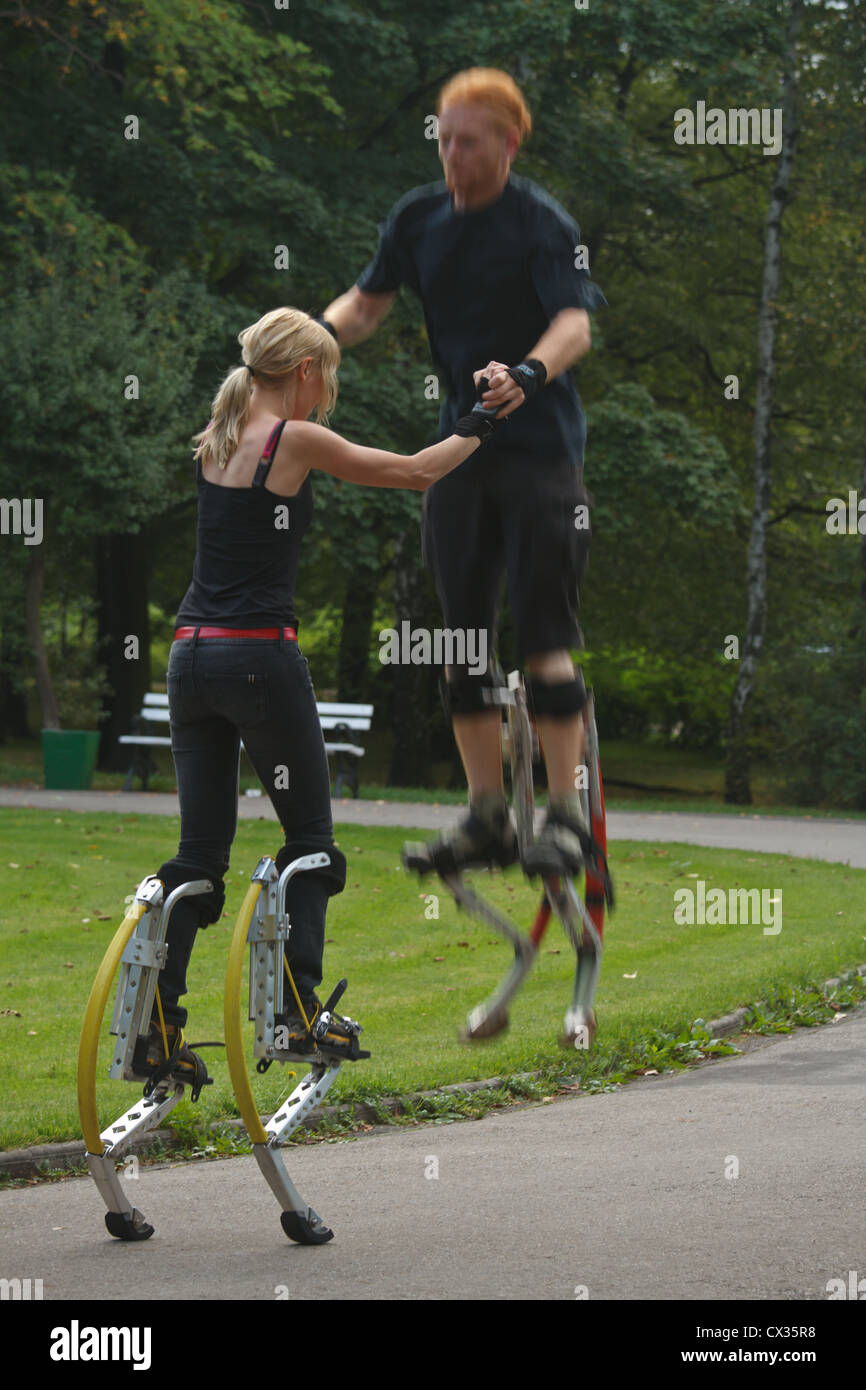 Young people wearing jumping stilts exercising in the park Stock Photo Alamy
