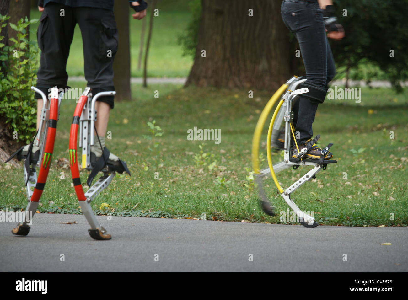 Young people wearing jumping stilts exercising in the park Stock Photo