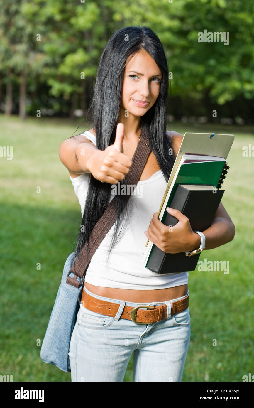 Ourdoors portrait of a gorgeous young student girl showing thumbs up ...