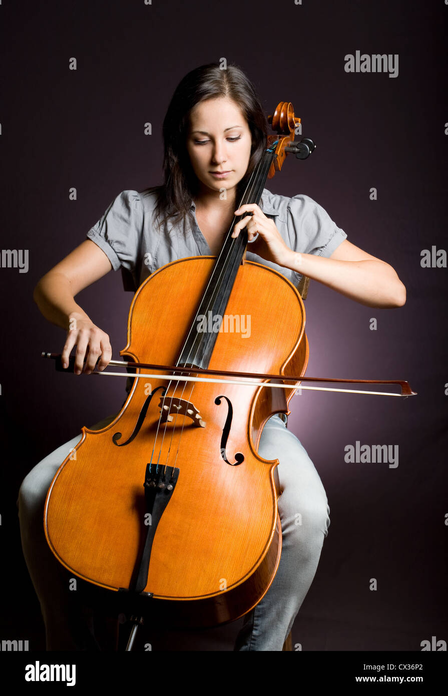 Portrait of beautiful young cellist immersed passionate in her music. Stock Photo